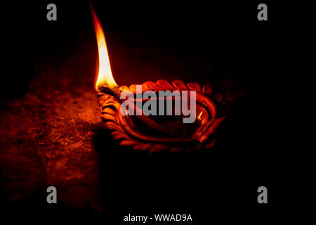 Chiudere l immagine di una argilla lit diya o la lampada sul pavimento il Diwali - un Indiano festival indù di luci isolate su sfondo nero. Foto Stock