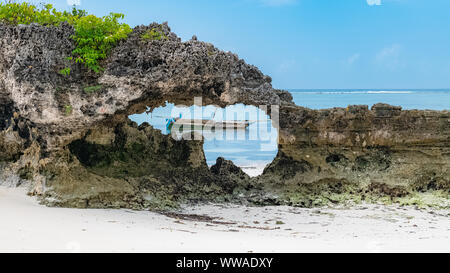 Zanzibar in Tanzania, tipica imbarcazione per la pesca su una bellissima spiaggia con onde Foto Stock