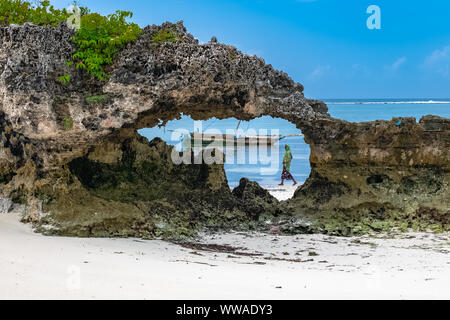 Zanzibar in Tanzania, tipica imbarcazione per la pesca su una bellissima spiaggia con onde Foto Stock