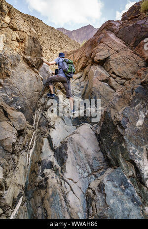 Un uomo è escursioni attraverso un wadi in montagne Hajar vicino Hatta Emirati arabi uniti Foto Stock