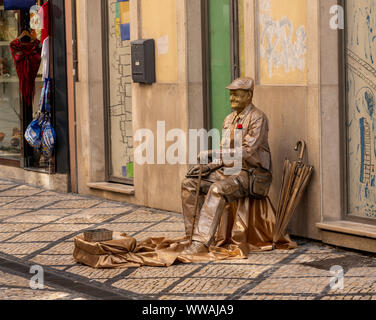 Statua vivente attore per le strade di Coimbra in Portogallo Foto Stock