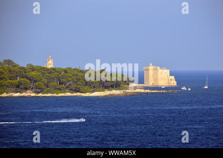 Torre della chiesa dell'abbazia di Lérins e il monastero fortificato su Saint Honorat isola nella baia al di fuori di Cannes, Cote d'Azur, in Francia, UE. Foto Stock