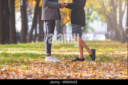Immagine ritagliata della giovane tenendo le mani nella foresta dorata Foto Stock