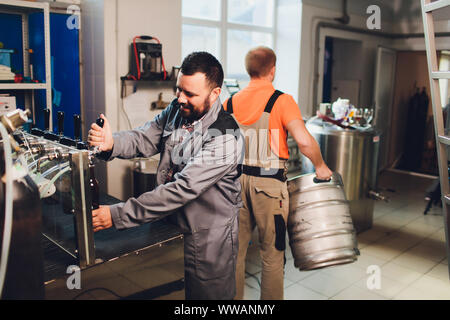 Ritratto di birraio che è la produzione della birra sul suo posto di lavoro nella brew-house. Foto Stock