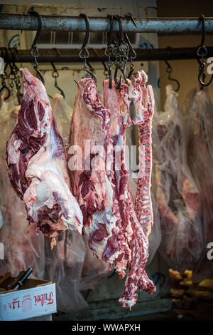 Xian, Cina - Luglio 2019 : Agnello e carcassa di vacca carne appesi ad un gancio in strada i fornitori di prodotti alimentari shop nel quartiere musulmano della città di Xian, Shaanxi Pro Foto Stock