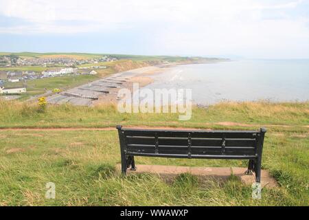 Panca su una collina. Da qui si ha una con la vista magnifica della spiaggia di St api. Costa Ovest dell'Inghilterra, nelle vicinanze del Lake District, a nord-ovest d'Europa. Foto Stock