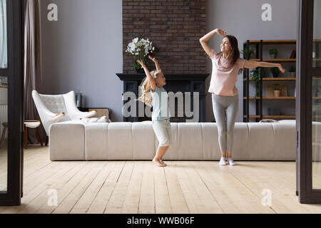 Overjoyed giovane madre ballare con poco carino adorabile figlia sorridente. Foto Stock