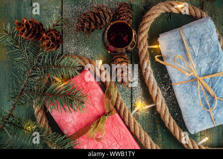 Bicchiere di vino rosso con doni e le luci di Natale dal di sopra Foto Stock