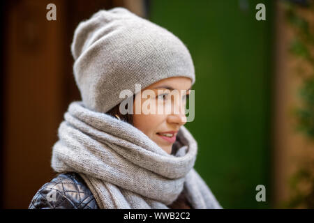 Bella donna in grigio di un berretto lavorato a maglia e sciarpa. Concetto lifestyle, autunno, urban. Foto Stock