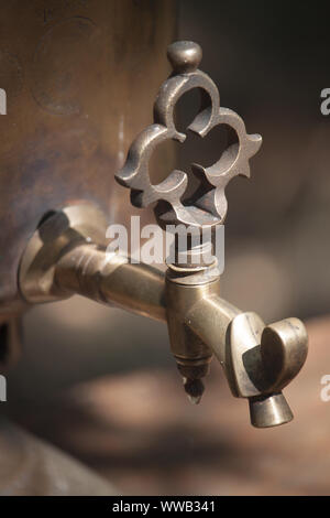 Dettaglio di un bronzo antico samovar la combustione del legno all'aperto, la preparazione di acqua per il tè di birra, il fuoco selettivo Foto Stock