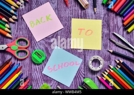 Idea creativa che raffigura il ritorno dei bambini a scuola. Forniture scolastiche con il testo torna a scuola. Foto Stock