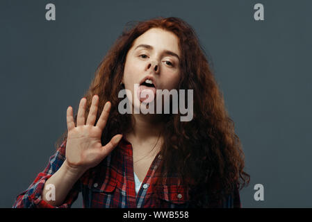 Volto di donna e la mano schiacciato sul vetro trasparente Foto Stock