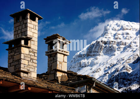 Camini in Pietra, un bel 'dettaglio' da Megalo Papigo village. Sullo sfondo uno dei vertici "torri" di Astraka, Zagori, Epiro, Grecia. Foto Stock