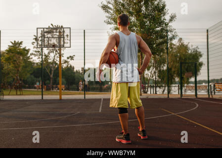 Muscolare di giocatore di basket sulla corte esterna Foto Stock