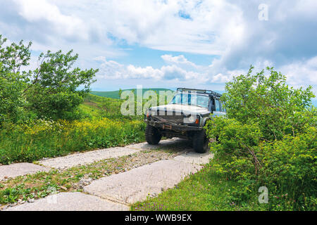 Mnt. Esecuzione, Ucraina - giu 19, 2019: vecchia fuoristrada sul lastricato della strada di montagna. sporchi SUV pronti per la battaglia con la natura. montagna nel dis Foto Stock