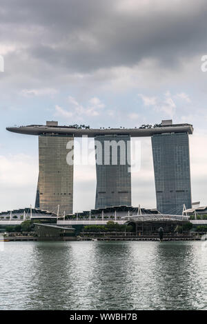 Singapore - Marzo 20, 2019: Closeup ritratto di Marina Bay sands hotel e casino con le sue tre torri visto da dietro bay sotto luce cloudscape. Foto Stock