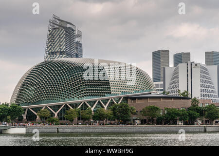 Singapore - Marzo 20, 2019: JW Marriott hotel tower dietro il duomo di Esplanade Theatre e più grattacieli a destra sotto cloudscape. Acqua marina, Foto Stock