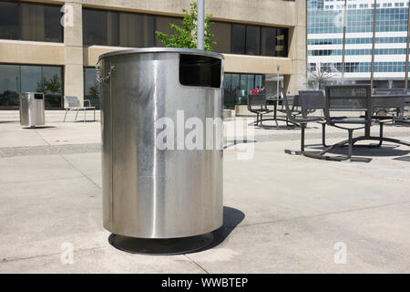 Una spazzatura di acciaio inossidabile può su un patio di cemento in uno spazio pubblico a Vancouver, B.C., Canada. Foto Stock