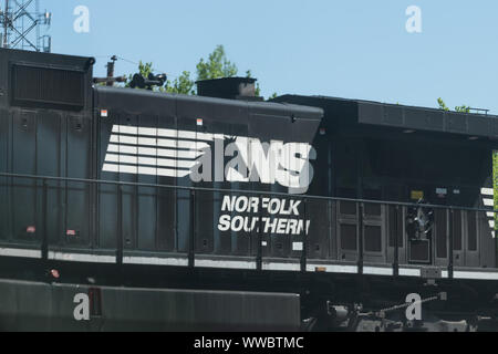 Atlanta, Stati Uniti d'America - 20 Aprile 2018: Norfolk Southern cargo locomotiva treno merci con vetture passando sui binari della ferrovia in Georgia downtown midtown città ho Foto Stock