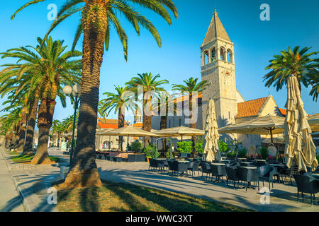 Viaggi popolari e località turistica con medievale lastricata promenade. Accogliente street cafe e ristorante con palme, Trogir, Dalmazia, Croazia, Europ Foto Stock