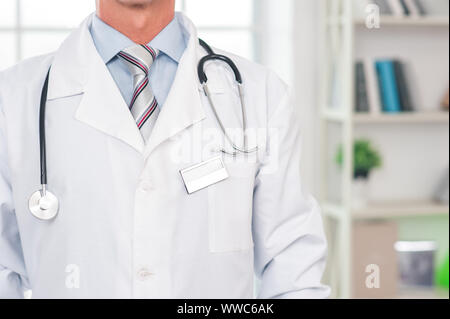 Medico senior presso il suo ufficio in ospedale vicino sicuro Foto Stock