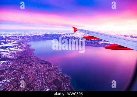 Una vista straordinaria dalla finestra del velivolo durante il tramonto sul Lago di Ginevra, Svizzera Foto Stock
