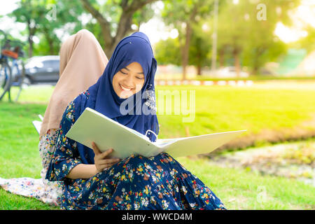 Adolescente giovane adulto asiatici musulmani Thai University College di lettura dello studente prenota insieme utilizzando per il concetto di istruzione Foto Stock