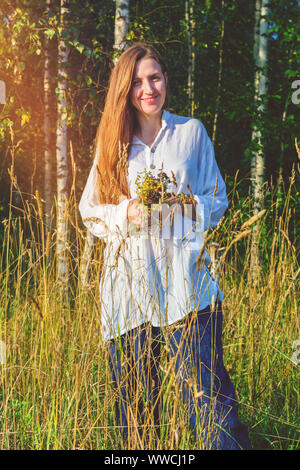 Ragazza raccoglie fiori selvatici ed erbe aromatiche Foto Stock