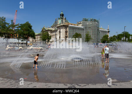 Bambini che giocano in acqua fontana a Karlsplatz, Monaco di Baviera, Germania. Foto Stock