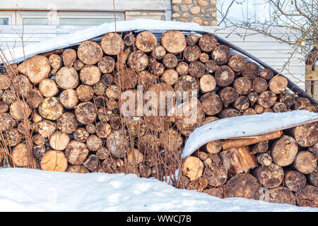 Catasta di legna da ardere sotto la neve in inverno Foto Stock