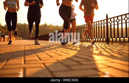 Un gruppo di giovani che corre lungo la strada nel parco. Foto Stock