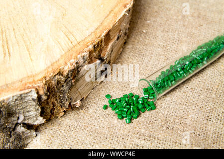 Palline di plastica .del colorante polimerico in tubi di prova su sfondo grigio. Granuli di plastica dopo la trasformazione di rifiuti di polietilene e polipropilene. Foto Stock