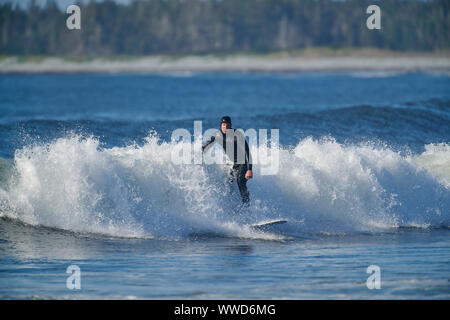 Surfer in sella a una piccola onda, Cherry Hill Beach, Nova Scotia, Canada Foto Stock