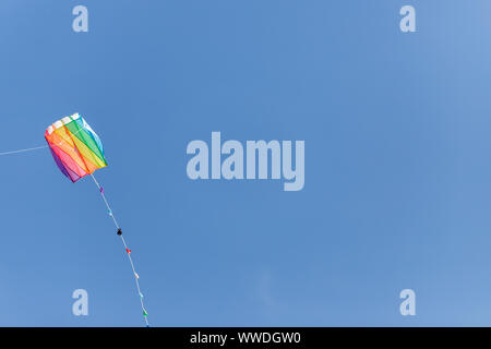 Vivacemente colorato aquilone nel vento su un cielo blu senza nuvole.sentire la libertà Foto Stock