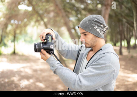 Uomo informale fotografo scattare foto e di modifica del video Foto Stock