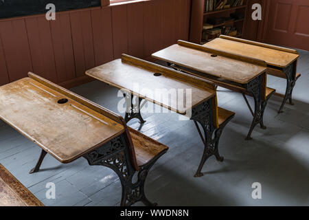 Scrivanie allineate in una vecchia scuola di camera house Foto Stock