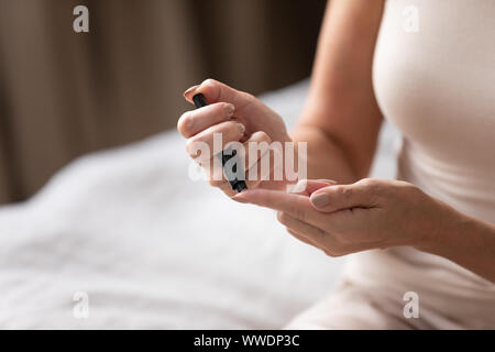 Donna matura mediante Misuratore glicemia close up Foto Stock