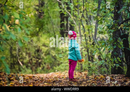 Bambina alimenta le carote di coniglio in una gabbia a profondità di campo Foto Stock