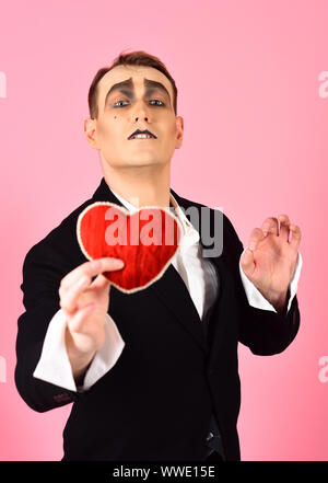 Sul serio qualcuno. La confessione di amore il giorno di San Valentino. Mime man tenere cuore rosso per il giorno di San Valentino. Attore Mime con amore il simbolo. Attore di teatro panto Foto Stock