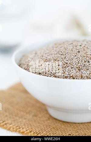 Tutto, organico bianco semi di chia mucchio in bianco ciotola con cucina luminosa sullo sfondo - Il fuoco selettivo Foto Stock