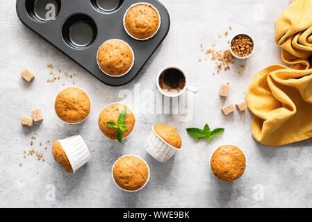 In casa deliziosi muffin vegetariano con lo zucchero di canna sul cemento grigio Sfondo, piana, laici vista superiore Foto Stock