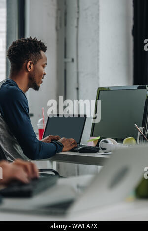 I giovani africani programmatore americano lavora in ufficio vicino a un collega Foto Stock