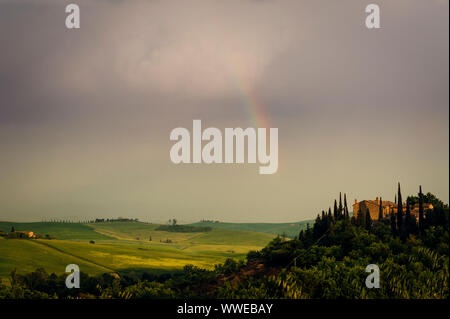 Rainbow con famosi cipressi nel cuore della Toscana vicino a Pienza, Italia Foto Stock