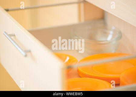 Vista laterale di arancio e contenitori in vetro in cucina in legno cassetti Foto Stock