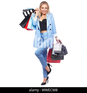 Bellissima ragazza con serrature di Hollywood, classic make-up in un elegante vestito blu e borse per lo shopping. Bellezza viso e corpo. Foto Stock