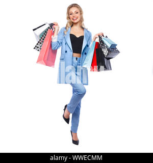 Bellissima ragazza con serrature di Hollywood, classic make-up in un elegante vestito blu e borse per lo shopping. Bellezza viso e corpo. Foto Stock