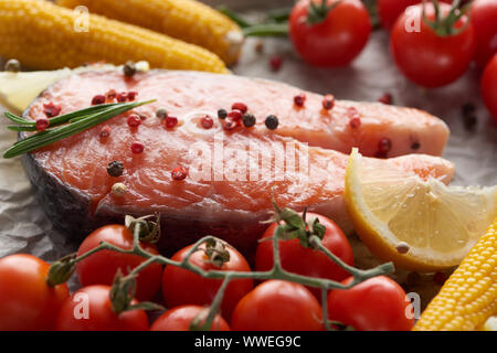 Materie di salmone fresco con spezie, limone e pomodori Foto Stock