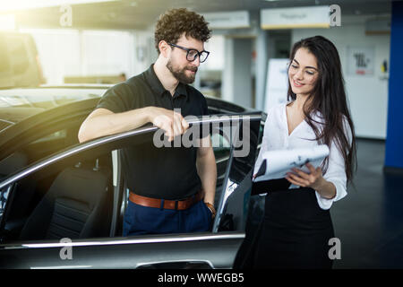 Professional splendida commessa alla concessionaria auto in abbigliamento formale. Super consulente e manager Foto Stock