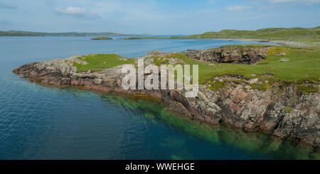 Costa rocciosa sull isola delle Ebridi di Lewis in estate mostra pura acqua blu e rocce sommerse Foto Stock