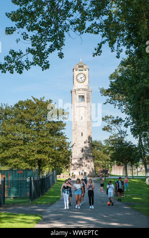 Un gruppo di giovani a piedi nella parte anteriore del Cocker torre dell orologio in una giornata di sole nel Parco di Stanley Blackpool Lancashire England Regno Unito. Foto Stock